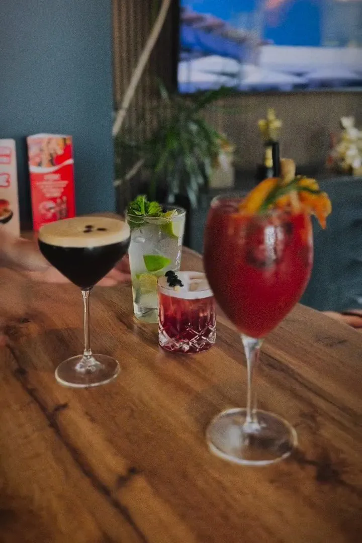 Četri kokteiļi uz koka bāra letes Amber Gastrobar